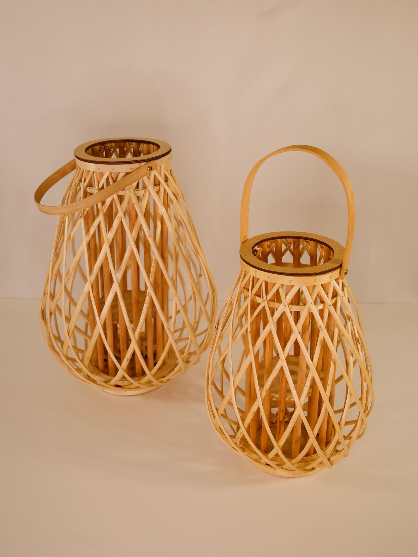 Two woven wooden lanterns with handles, placed on a neutral background.