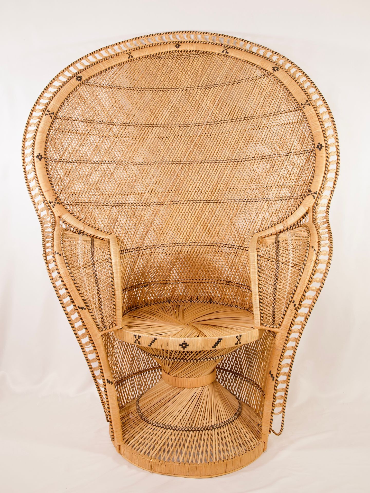 Large wicker peacock chair with intricate weaving and detailing, featuring a high back and rounded seat.