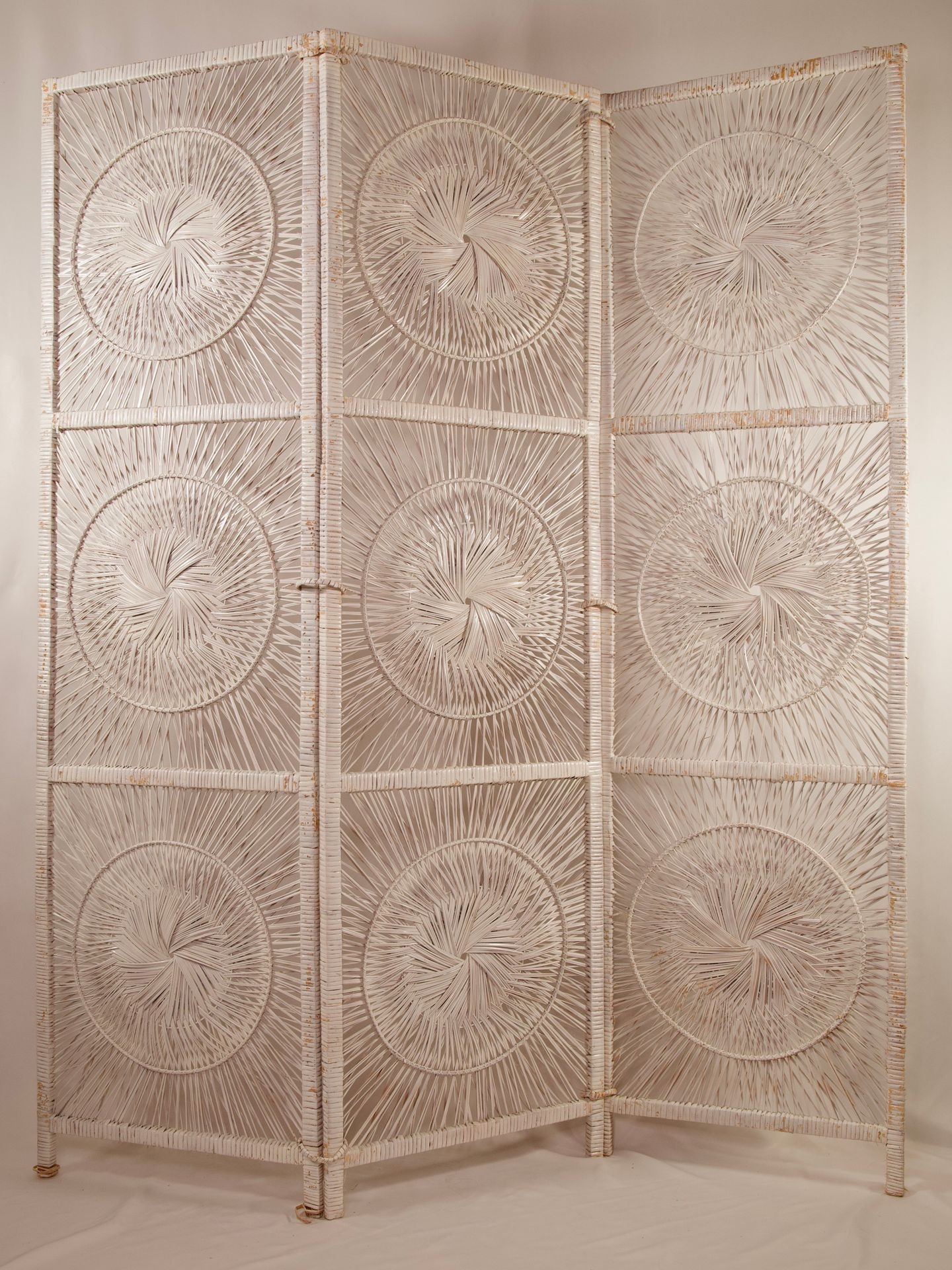 Ornate three-panel room divider with intricate circular woven patterns on each panel.