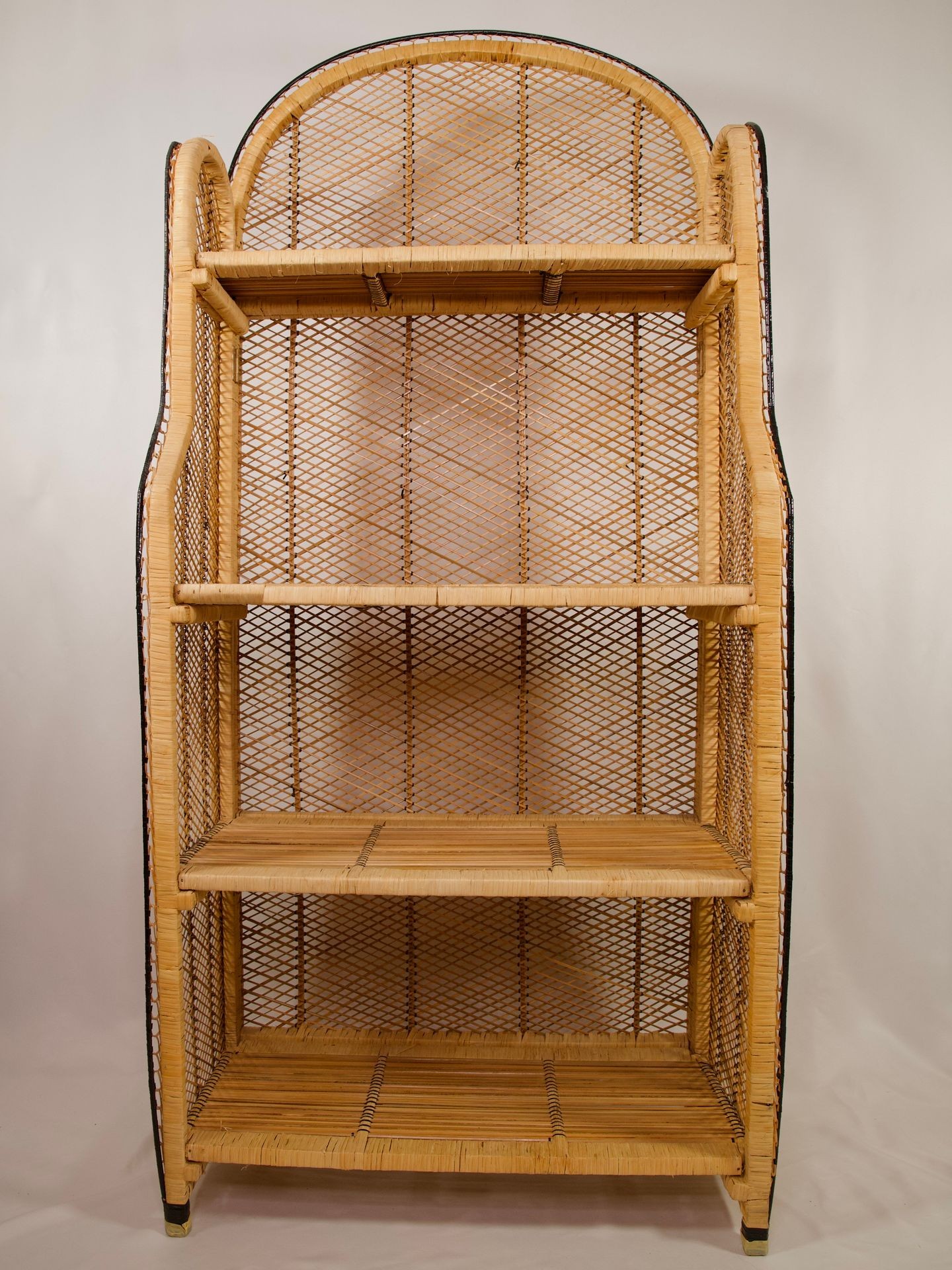 Empty wicker bookshelf with three shelves and a curved top, set against a plain white background.