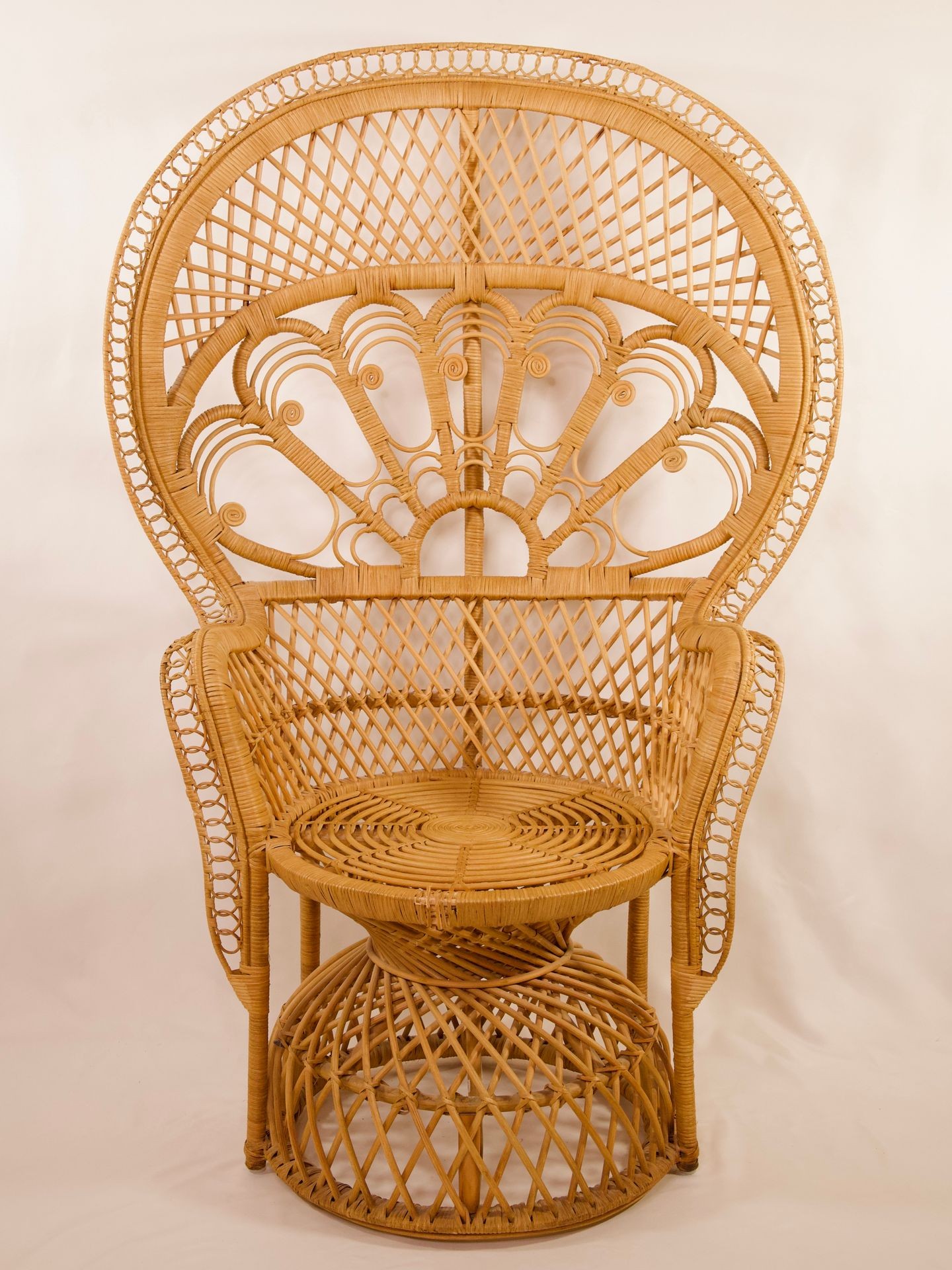 Intricately woven, high-back wicker chair with an ornate design and rounded seat.